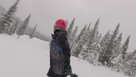 Female-snowboarder-riding-through-fresh-powder-at-Colorado-ski-resort,-handheld
