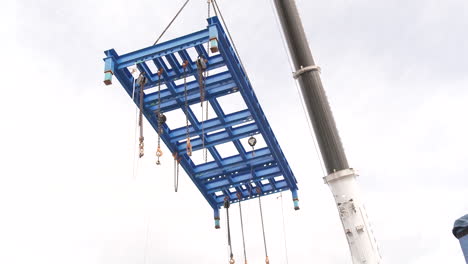 Crane-Boom-Lifting-Metal-Frame-At-Construction-Site