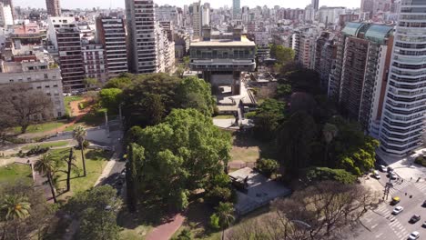 Aerial-shot-of-National-Library-of-Buenos-Aires-surrounded-by-skyscraper-buildings-and-Apartments-during-sunny-day---Traffic-on-the-road-during-sunny-day