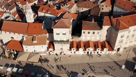 Luftaufnahme-Von-Menschen,-Die-Im-Sommer-An-Der-Promenade-Mit-Venezianischer-Architektur-In-Der-Altstadt-Von-Trogir-In-Kroatien-Spazieren-Gehen