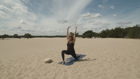 Frau,-Die-Sich-Auf-Einer-Yogamatte-In-Sanddünen-Ausdehnt
