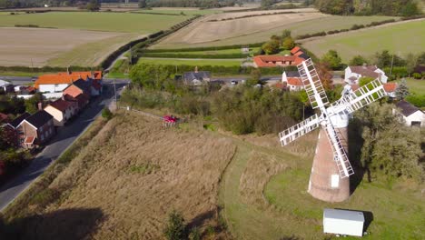 Billingford-Windmill-at-farmland-area-with-house-and-roads-in-Diss,-Norfolk---aerial-drone-flying-tracking-shot