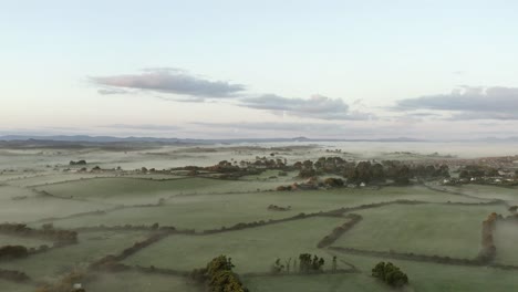 Foggy-green-agricultural-fields,-morning-aerial-in-southern-Ireland