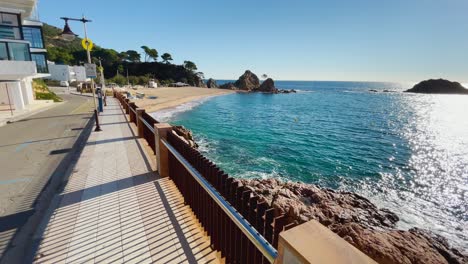 Tossa-de-Mar-bay-seen-from-the-castle-to-the-beach-with-coarse-sand-and-turquoise-blue-sea-water-old-walled-medieval-village-fishing-village-Mediterranean-sea-walking-along-the-promenade