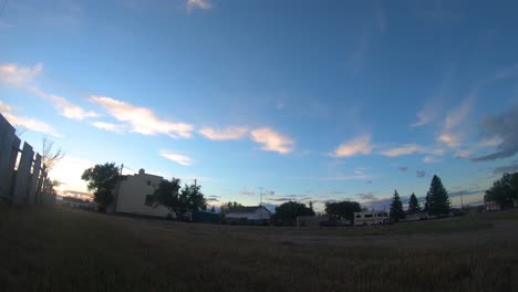 Timelapse---Blick-Auf-Die-Wolken,-Die-Tagsüber-über-Einige-Gebäude-Gegenüber-Einem-Feld-In-Empress-Alberta-Canada-Ziehen