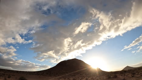 Die-Sonne-Geht-über-Der-Mojave-wüste-Mit-Einem-Dynamischen-Wolkenbild-zeitraffer-über-Dem-Kuppelförmigen-Berg-Auf