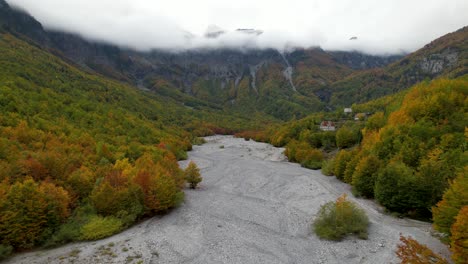 Pueblo-De-Montaña-En-Los-Remotos-Alpes-De-Albania-Con-Bosque-Colorido-En-Otoño-Bajo-Las-Nubes