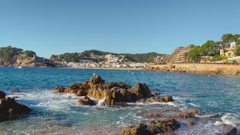 rocks-in-the-foreground-with-the-bay-of-Tossa-de-Mar-in-the-background-castle-and-walled-enclosure