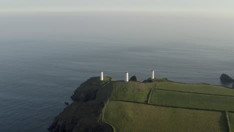 Irish-coastal-aerial:-Metal-Man-beacon,-three-towers-protect-sailors