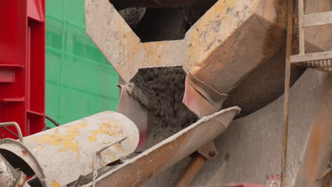 Cement-pouring-out-of-back-of-cement-truck-at-construction-site,-close-up