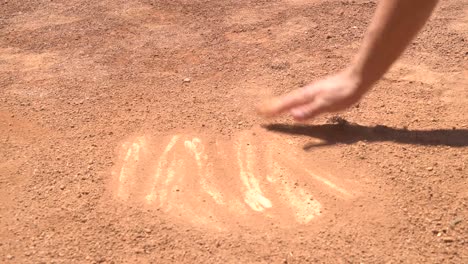 Wiping-Dirt-of-Home-Plate-With-Hand