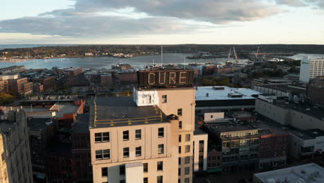Beautiful-oscillating-aerial-shot-of-the-Time-and-Temperature-building-in-front-of-Casco-Bay-in-Portland,-Maine