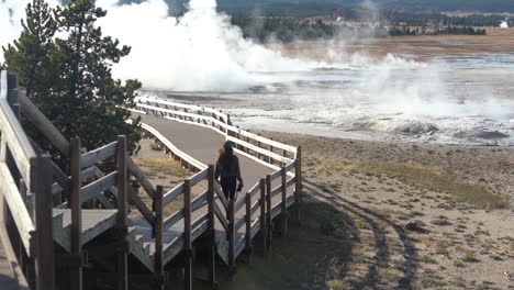 Woman-Walking-on-Path-by-Geysers-of-Yellowstone-National-Park,-Wyoming-USA,-Full-Frame