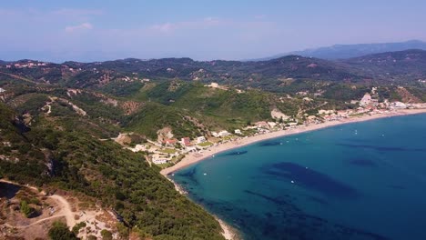Drohnenaufnahme-Einer-Riesigen-Bucht-Mit-Blauem-Wasser,-Langem-Sandstrand-Und-Schwimmenden-Booten-In-Griechenland