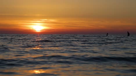 Zwei-Jungs-Schwimmen-Bei-Sonnenuntergang-Im-Meer,-Gesichter-Sind-Nicht-Zu-Sehen,-Menschliche-Silhouetten