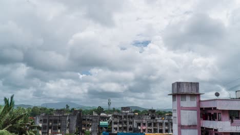 Time-Lapse-Small-town-suburb,-Clouds-moving-fast,-Mountain-layers-in-distance