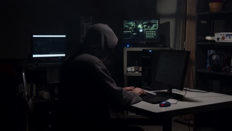 Computer-Hacker-types-in-computer-code-in-a-back-room