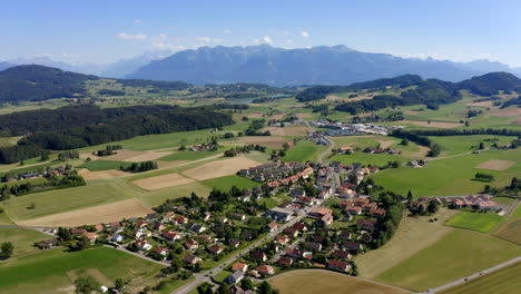 Scenic-View-Of-Forel-Village-In-The-Swiss-Countryside-With-Alps-Mountains-In-Background,-Switzerland---aerial-drone