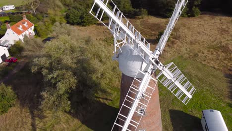Billingford-Windmill-at-a-farm-field-area-with-house-in-Diss,-Norfolk---aerial-drone-flying-tracking-shot