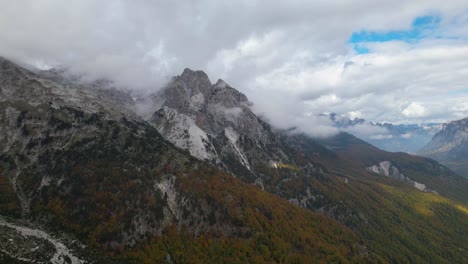 Great-mountains-in-Alps-of-Albania-covered-in-fog-at-Autumn-season-with-colorful-forest