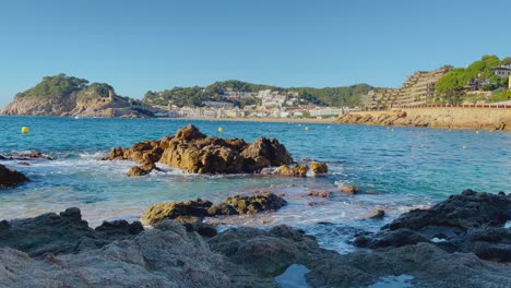 rocks-in-the-foreground-with-the-bay-of-Tossa-de-Mar-in-the-background-castle-and-walled-enclosure