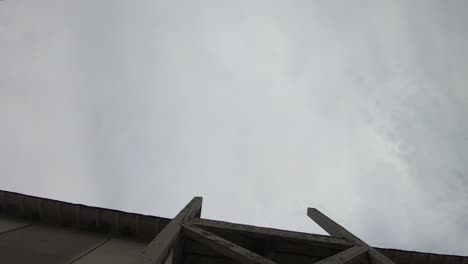 TIMELAPSE---Looking-straight-up-at-the-clouds-in-front-of-a-building-on-a-cloudy-day
