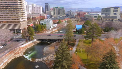 Aerial-over-the-Truckee-River-in-Reno,-Nevada-with-cars-passing-by-on-the-overpass