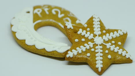 Zoomed-in-confectionery-gingerbread-with-white-decoration-on-top-in-the-shape-of-a-bell-and-horseshoe-pf-on-a-white-background