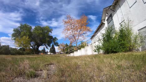 TIMELAPSE---Looking-towards-the-sky-at-the-clouds-out-a-old-abandoned-hospital-in-a-small-town-on-a-sunny-day