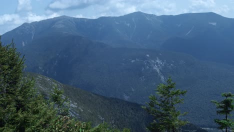 Mountain-peaks-lie-within-the-white-mountains-of-New-Hampshire-as-the-camera-pans-to-reveal-a-winding-road