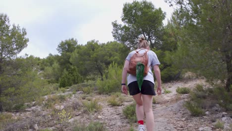 Young-blonde-girl-hiking-in-Alcoi-mountains-forest,Spain,slow-motion