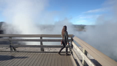 Female-Photographer-Walking-on-Lookout-Above-Steam-in-Yellowstone-National-Park,-Wyoming-USA,-Full-Frame