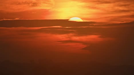 Die-Morgensonne-Geht-Im-Sommer-Mit-Horizontalen-Wolken-Bedeckt-Auf-Und-Enthüllt-Einen-Sonnenaufgang-Mit-Warmen-Und-Heißen-Farben-Von-Orange,-Rot,-Gelb-Und-Einigen-Landschaftssilhouetten