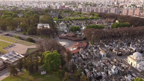 Drone-flying-over-Church-of-Chacarita-Cemetery-with-Buenos-Aires-cityscape-in-background