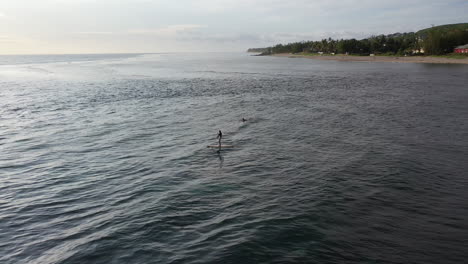 Paddleboarder-and-a-surfer-enjoying-the-calm-waters-around-Reunion-Island-as-the-sun-sets