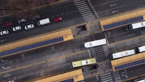 Aerial-top-down-shot-of-arriving-bus-at-Chacarita-Bus-Station-in-Buenos-Aires-and-driving-cars-on-the-road