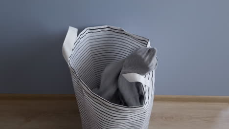 Throwing-dirty-clothes-in-the-laundry-basket