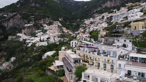 Drone-View-Flying-Over-Hillside-Terrace-Villas,-Narrow-Streets,-and-Ancient-Roman-Ruins-of-Positano-Town-Italy