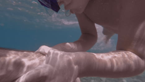Toddler-snorkeling-with-fishes-around,-underwater-footage-from-Kalamata,Greece
