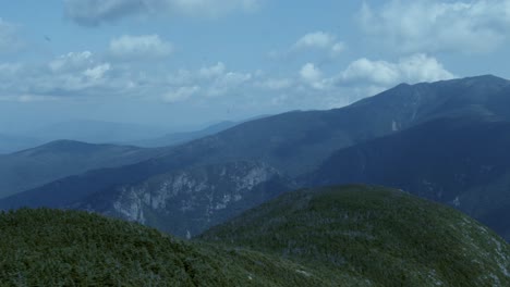 The-white-mountains-of-New-Hampshire-beneath-a-cloudy-blue-sky-as-the-camera-pans