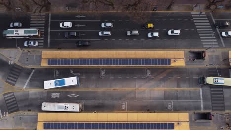Ascending-aerial-birds-eye-of-busy-traffic-on-multilane-road-and-bus-stop-in-Capital-of-Argentina