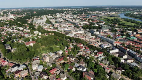 Zaliakalnis-private-homes-and-downtown-of-Kaunas-city,-aerial-fly-back-view