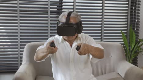 Asiatischer-Alter-Mann-Mit-Grauen-Haaren,-Der-Virtuelle-Realität-Vr-Spielt-Und-Videospiele-Fröhlich-Auf-Einem-Sofa-Im-Wohnzimmer-Zu-Hause-Genießt