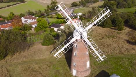 Flying-over-Billingford-Windmill-at-a-farmland-area-with-house-in-Diss,-Norfolk---aerial-drone-backward-shot