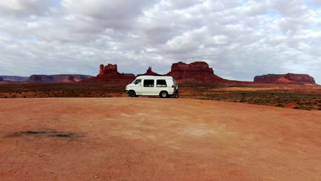 Drone-Shot-flying-towards-van-lifers-and-a-woman-exercising-in-Monument-Valley