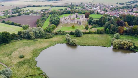 Aerial:-Framlingham-Castle-with-lake-and-agricultural-land-at-Suffolk,-England---drone-flying-forward-shot