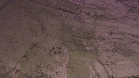 Aerial-shot-reversing-and-tilting-up-to-a-reservoir-and-moorland-at-golden-hour