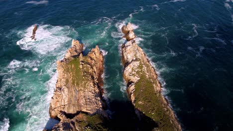 Aerial-top-down-natural-seascape-rock-formation-waves-crashing-over-the-cliff