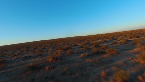 Fast,-low-altitude-first-person-flight-over-the-Mojave-Desert's-barren-wasteland-at-dawn