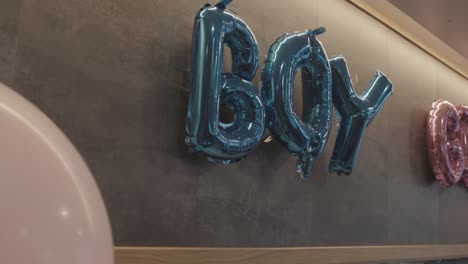 Blue-boy-balloons-hanging-on-wall,-gender-reveal-party-indoor,-slow-motion
